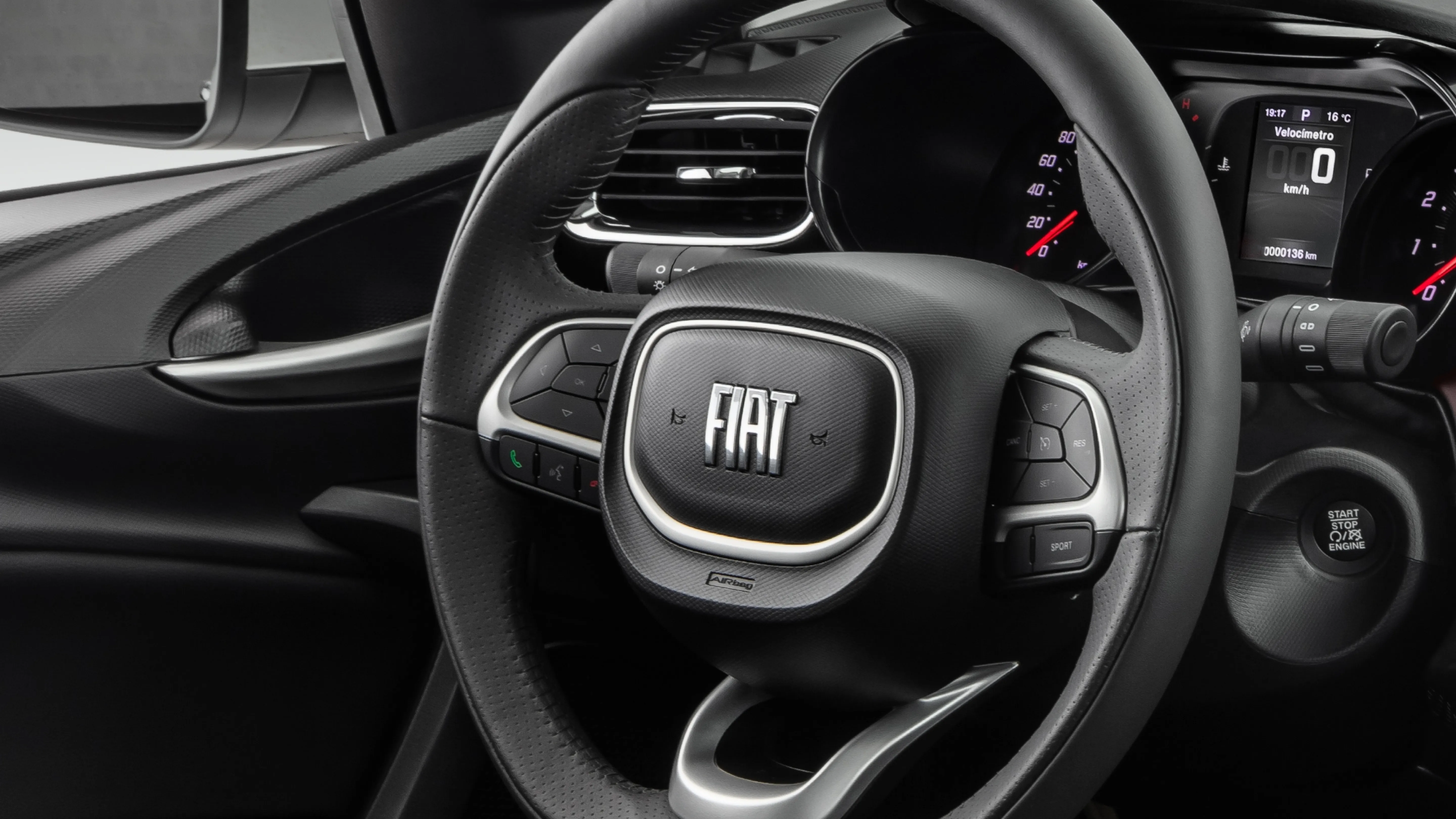 Interior do Fiat cronos com destaque para volante multifuncional, com botões para controlar a central multimídia e atender ou recusar chamadas.